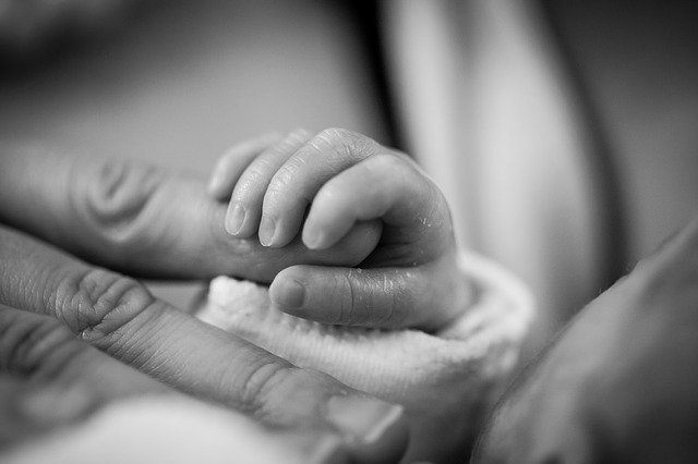 赤ちゃんが母親の人差し指を握る